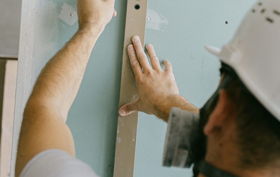 pexels photo 5493674 5493674 Construction worker measuring a wall with a level for accurate alignment.